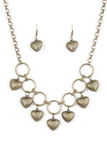 Stamped in whimsical patterns, vintage inspired hearts cascade from the bottom of airy brass hoops, creating a romantic fringe below the collar. Features an adjustable clasp closure.  Sold as one individual necklace. Includes one pair of matching earrings.