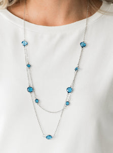 Varying in size, glassy blue gems trickle along dainty silver chains, creating sparkling layers across the chest. Features an adjustable clasp closure.  Sold as one individual necklace. Includes one pair of matching earrings.