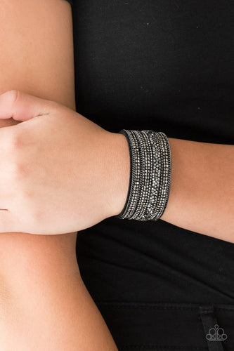 Rows of shimmery gunmetal chains, glittery hematite rhinestones, and metallic prism rhinestones are sprinkled along a thick black suede band for a sassy style. Features an adjustable snap closure.  Sold as one individual bracelet.  Always nickel and lead free.