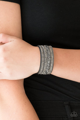 Rows of shimmery gunmetal chains, smoky rhinestones, and metallic prism rhinestones are sprinkled along a thick gray suede band for a sassy style. Features an adjustable snap closure.  Sold as one individual bracelet.  Always nickel and lead free.