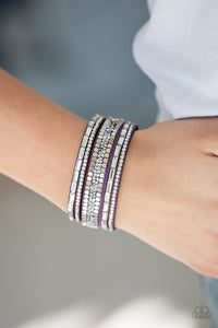 Featuring round and emerald style cuts, glassy white rhinestones join flat silver cubes and metallic prism rhinestones along a purple suede band for a sassy look. Features an adjustable snap closure.  Sold as one individual bracelet.   Always nickel and lead free.