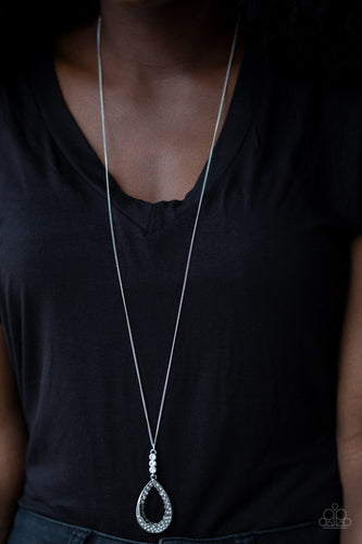 Infused with a lengthened silver chain, three white rhinestones give way to a glittery teardrop pendant. Dotted with dainty silver studs, the inside and outside of a silver teardrop is encrusted in white rhinestones for a regal look. Features an adjustable clasp closure.  Sold as one individual necklace. Includes one pair of matching earrings.  Always nickel and lead free.