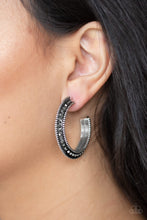 Load image into Gallery viewer, The top half of a bold silver frame is encrusted in hematite rhinestones, giving way to glistening silver studs for an edgy finish. Earring attaches to a standard post fitting. Hoop measures approximately 1 1/4&quot; in diameter.  Sold as one pair of hoop earrings. Always nickel and lead free.