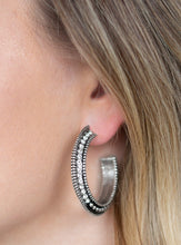 Load image into Gallery viewer, The top half of a bold silver frame is encrusted in glassy white rhinestones, giving way to glistening silver studs for an edgy finish. Earring attaches to a standard post fitting. Hoop measures approximately 1 1/4&quot; in diameter.  Sold as one pair of hoop earrings.  