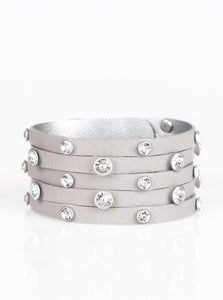 Dotted with glassy white rhinestones, a thick gray leather band has been spliced into five glittery strands around the wrist for a sassy look. Features an adjustable snap closure.  Sold as one individual bracelet.