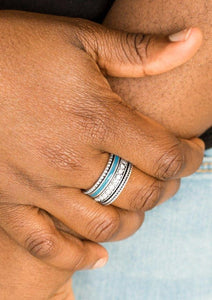 A shiny blue strip of color runs along the bottom of a row of glassy white rhinestones. Infused with silver textures, the mismatched details coalesce into one thick band across the finger. Features a stretchy band for a flexible fit.  Sold as one individual ring.  Always nickel and lead free.
