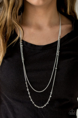 Brushed in an iridescent finish, silver crystal-like beads trickle along a shimmery silver chain. A plain silver chain hangs above the glittery beads for a refined layered finish. Features an adjustable clasp closure.  Sold as one individual necklace. Includes one pair of matching earrings.  Always nickel and lead free.