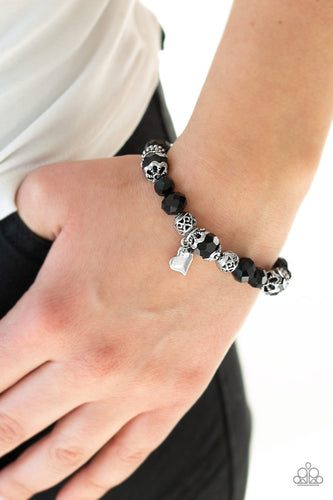 A collection of black crystal-like beads and ornate silver beads are threaded along a stretchy band around the wrist. An abstract silver heart charm swings from the center, for a romantic finish.  Sold as one individual bracelet. Always nickel and lead free.