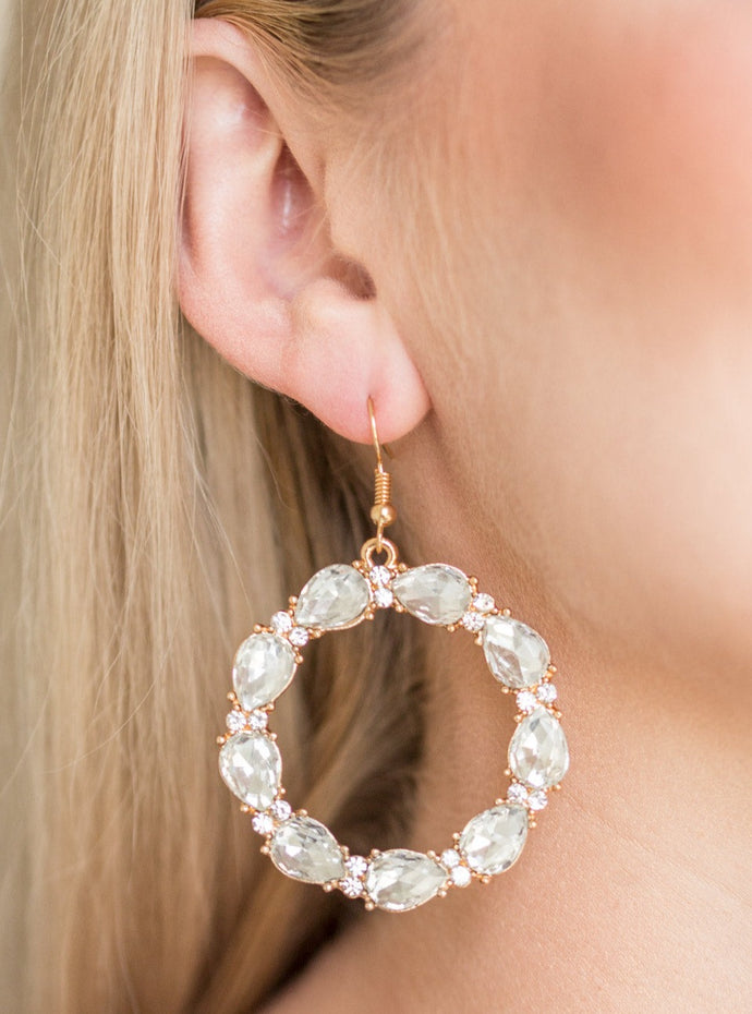 Glittery white rhinestones and white teardrop gems circle into a sparkling hoop for a glamorous look. Earring attaches to a standard fishhook fitting.  Sold as one pair of earrings.  