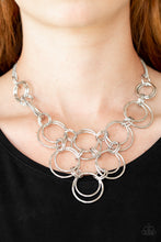Load image into Gallery viewer, Attached to two bent silver bars, delicately hammered asymmetrical silver hoops link below the collar for an edgy statement making look. Features an adjustable clasp closure.  Sold as one individual necklace. Includes one pair of matching earrings.  Always nickel and lead free.