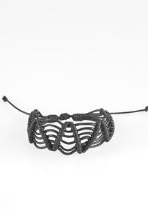 Black twine knots around shiny black cording, creating a netted pattern around the wrist. Features an adjustable sliding knot closure.  Sold as one individual bracelet.  