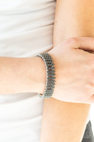 Dainty silver beads and stacked silver frames radiating with sunburst patterns are threaded along stretchy bands around the wrist for a whimsical look.  Sold as one individual bracelet.  