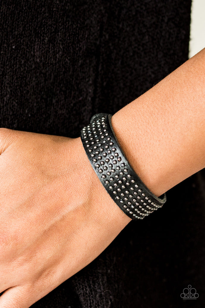 Dainty metallic beads are pressed across the front of a black leather band for a rugged look. Features an adjustable snap closure.  Sold as one individual bracelet.  Always nickel and lead free.