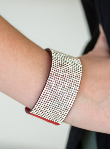 Row after row of glassy white rhinestones are encrusted along a thick red suede band, creating knockout shimmer across the wrist. Features an adjustable snap closure.  Sold as one individual bracelet.