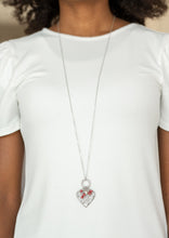 Load image into Gallery viewer, Infused with dainty red pearls and a shimmery silver heart charm, a stenciled silver heart pendant swings from the bottom of a lengthened silver chain for a whimsical look. Features an adjustable clasp closure.  Sold as one individual necklace. Includes one pair of matching earrings. 