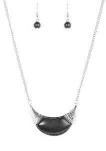A smooth black stone is pressed into the center of a crescent-shaped frame, creating a tribal inspired pendant below the collar. The glistening silver frame is delicately scratched in shimmer for a handcrafted, artisanal finish. Features an adjustable clasp closure.  Sold as one individual necklace. Includes one pair of matching earrings.