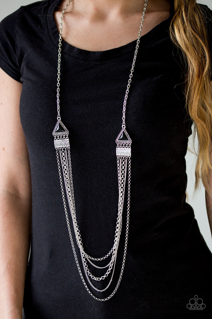 Mismatched silver chains stream from the bottom of ornate silver frames, creating edgy layers down the chest. Featuring triangular shapes, faceted black beads are pressed into studded silver frames, creating tribal inspired accents. Features an adjustable clasp closure.  Sold as one individual necklace. Includes one pair of matching earrings.  Always nickel and lead free.