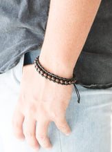 Load image into Gallery viewer, Earthy wooden beads are threaded along black shiny cording around the wrist for a seasonal look. Features an adjustable sliding knot closure.  Sold as one individual bracelet.