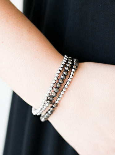 Brushed in an iridescent finish, faceted hematite beads and glistening silver beads are threaded along elastic stretchy bands, creating colorful layers across the wrist.  Sold as one set of three bracelets.  