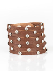 A thick brown leather band has been spliced into numerous brown strands. Featuring sleek silver frames, glittery white rhinestones are sprinkled across the leather bands for a sassy finish. Features an adjustable snap closure. Sold as one individual bracelet.