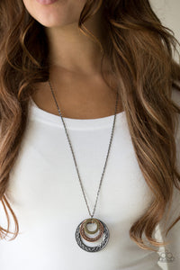 Embossed in swirling tribal detail, brass, copper, and gunmetal frames swing from the bottom of an elongated gunmetal chain, creating an airy stacked pendant. Features an adjustable clasp closure.  Sold as one individual necklace. Includes one pair of matching earrings.  Always nickel and lead free.