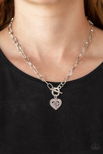 An ornate silver heart pendant swings below the collar for a vintage inspired look. Features a toggle closure.  Sold as one individual necklace. Includes one pair of matching earrings.  Always nickel and lead free.
