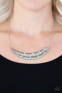 Dotted in sections of glittery white rhinestones, a lifelike silver feather pendant is suspended horizontally below the collar for a seasonal look. Features an adjustable clasp closure.  Sold as one individual necklace. Includes one pair of matching earrings.  Always nickel and lead free.