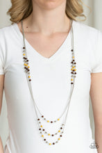 Load image into Gallery viewer, Dainty silver, yellow, and wooden beads trickle along three shimmery silver chains, creating colorful layers across the chest. Features an adjustable clasp closure.  Sold as one individual necklace. Includes one pair of matching earrings. Always nickel and lead free.