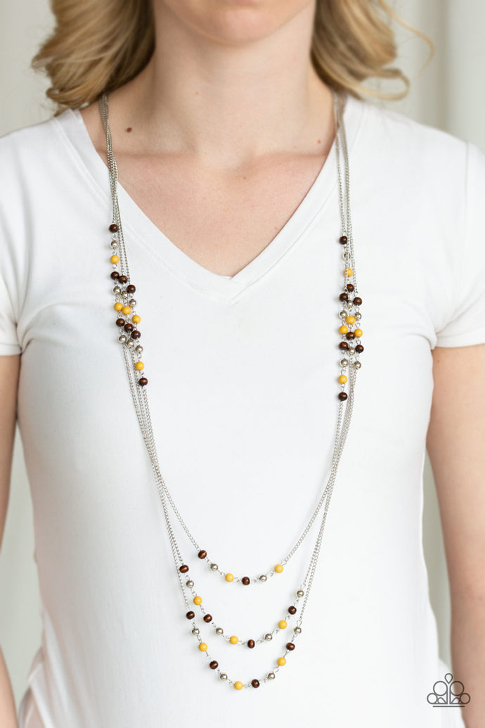 Dainty silver, yellow, and wooden beads trickle along three shimmery silver chains, creating colorful layers across the chest. Features an adjustable clasp closure.  Sold as one individual necklace. Includes one pair of matching earrings. Always nickel and lead free.