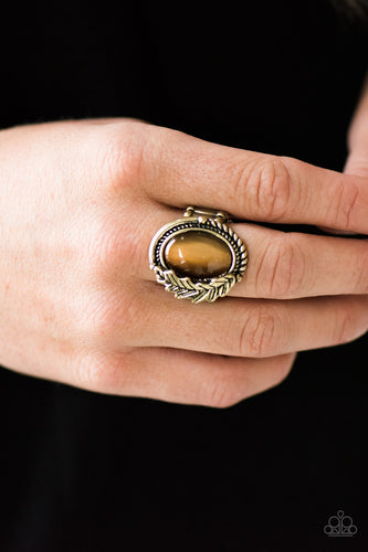 A luminescent brown moonstone is pressed into the center of a textured brass frame. Brushed in a glistening finish, a leafy brass charm adorns one side of the stone for a seasonal finish. Features a stretchy band for a flexible fit.  Sold as one individual ring.  Always nickel and lead free.