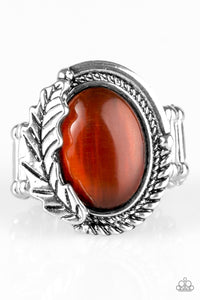 A luminescent orange moonstone is pressed into the center of a textured silver frame.