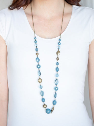 Varying in opacity and shape, a collection of polished, pearly, and glassy blue beads link with antiqued brass beads across the chest for a whimsical finish. Features an adjustable clasp closure.  Sold as one individual necklace. Includes one pair of matching earrings.  Always nickel and lead free.