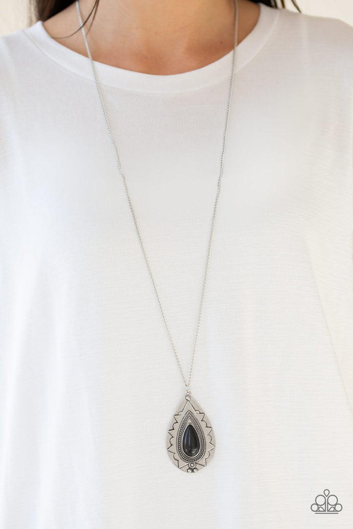 Chiseled into a tranquil teardrop, an earthy black stone is pressed into an ornate silver frame. The whimsical pendant swings from the bottom of a lengthened silver chain for a seasonal look. Features an adjustable clasp closure.  Sold as one individual necklace. Includes one pair of matching earrings.  Always nickel and lead free.