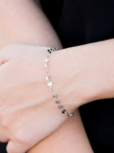 Dainty flat silver discs link across the wrist in an undeniably shimmery fashion. Features an adjustable clasp closure.  Sold as one individual bracelet.