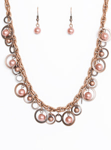 Brushed in an antiqued shimmer, mismatched copper hoops, copper pearls, and dainty copper beads swing from the bottom of a bold copper chain below the collar for a refined look. Features an adjustable clasp closure.  Sold as one individual necklace. Includes one pair of matching earrings.