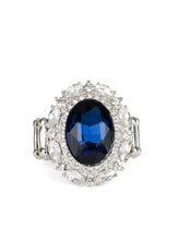 Load image into Gallery viewer, An over sized oval blue gem is pressed into the center of a round silver frame encrusted in mismatched white rhinestones for a glamorous look. Features a stretchy band for a flexible fit.  Featured inside The Preview at ONE Life!   Sold as one individual ring.   