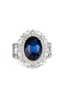 An over sized oval blue gem is pressed into the center of a round silver frame encrusted in mismatched white rhinestones for a glamorous look. Features a stretchy band for a flexible fit.  Featured inside The Preview at ONE Life!   Sold as one individual ring.   