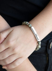 A collection of speckled stones, dainty silver beads, and a silver plate stamped with the inspirational word, "blessed", are threaded along a stretchy band around the wrist for a seasonal look.  Sold as one individual bracelet.