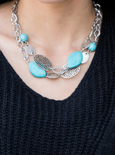 Load image into Gallery viewer, Etched in shimmery textures, a chunky silver chain gives way to a collection of refreshing turquoise stones and hammered silver accents. Each featuring patterns derived from nature, the glistening discs join into a layered artisan arrangement below the collar. Features an adjustable clasp closure.  Sold as one individual necklace. Includes one pair of matching earrings.