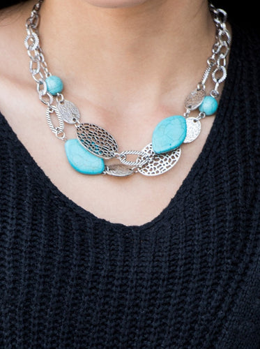 Etched in shimmery textures, a chunky silver chain gives way to a collection of refreshing turquoise stones and hammered silver accents. Each featuring patterns derived from nature, the glistening discs join into a layered artisan arrangement below the collar. Features an adjustable clasp closure.  Sold as one individual necklace. Includes one pair of matching earrings.