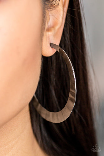 Brushed in a high-sheen finish, a delicately hammered silver hoop curls around the ear for a fierce look. Earring attaches to a standard post fitting. Hoop measures 2 1/2