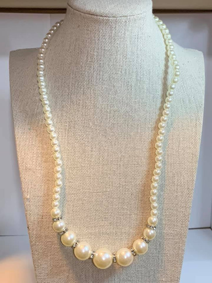 Threaded along an invisible wire, dainty white pearls give way to an alternating collection of larger white pearls and white rhinestone encrusted rings below the collar for a timeless sparkle. Features an adjustable clasp closure.  Sold as one individual necklace. Includes one pair of matching earrings.  Always nickel and lead free.  Exclusive!!