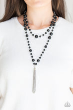 Load image into Gallery viewer, A collection of bubbly black beads link into two strands down the chest. A shimmery silver tassel swings from the lowermost strand, adding a timeless twist to the classic beaded palette. Features an adjustable clasp closure.  Sold as one individual necklace. Includes one pair of matching earrings.   Always nickel and lead free.