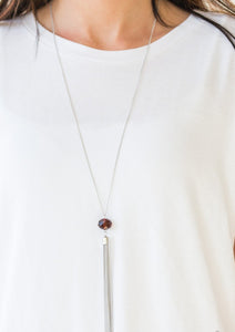 A glittery brown crystal-like bead swings from the bottom of a lengthened silver chain, giving way to a shimmering silver tassel for a glamorous finish. Features an adjustable clasp closure.  Sold as one individual necklace. Includes one pair of matching earrings.  Always nickel and lead free.