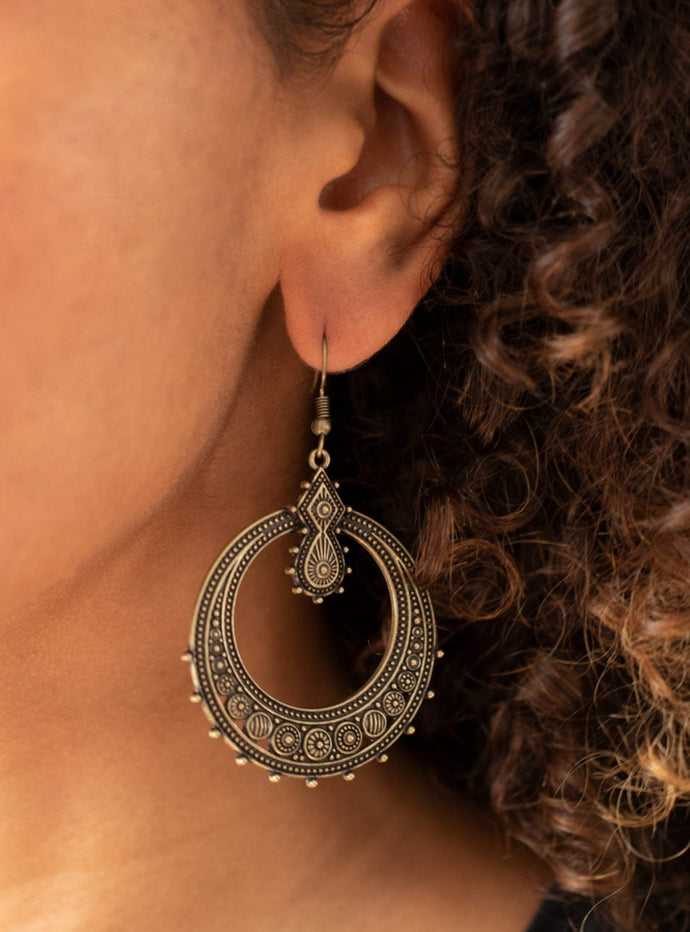 Featuring striped and floral patterns, dainty brass beads dot the bottom of a studded brass hoop that is attached to a matching ornate brass fitting for a tribal inspired look. Earring attaches to a standard fishhook fitting.  Sold as one pair of earrings. 