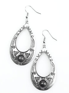 Stamped in tribal inspired patterns, a glistening silver teardrop swings from the ear in a whimsical fashion. A smooth black stone is pressed into the bottom of the frame, adding an earthy flair to the indigenous lure. Earring attaches to a standard fishhook fitting.  Sold as one pair of earrings.
