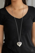 Load image into Gallery viewer, Chiseled into a flirtatious heart shape, a refreshing white stone joins an ornate silver heart frame at the bottom of a lengthened silver chain for a whimsical look. Features an adjustable clasp closure.  Sold as one individual necklace. Includes one pair of matching earrings.  Always nickel and lead free.