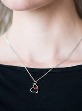 Load image into Gallery viewer, A solitaire red rhinestone sits off center inside of a silver heart frame, creating a timeless pendant below the collar. Features an adjustable clasp closure.  Sold as one individual necklace. Includes one pair of matching earrings.