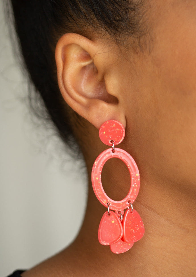 Sparkle flecked coral acrylic frames link into an abstract lure for a summery look. Earring attaches to a standard post fitting.  Sold as one pair of post earrings.  
