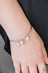 A skinny silver bar arcs across the wrist, creating a dainty cuff. Secured in place, glittery white rhinestones swing from the wrist for a glamorous finish.  Sold as one individual bracelet.  Always nickel and lead free.